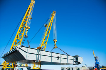 Wall Mural - Loading in port. Floating port crane on blue sky background