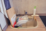 Fototapeta  - Kitchen sink filled to the top with dirty unwashed dishes before and after washing, concept