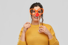 Red Nose Day, Party Props And Photo Booth Concept - Portrait Of Happy Smiling Young Woman With Clown Nose And Big Glasses Over Grey Background