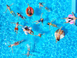 © artiemedvedev - Aerial of friends having party in swimming pool with inflatable flamingo, swan, mattress. Happy young people relax at luxury resort on sunny day. View from above. Girls in bikini sunbathing in a sun.