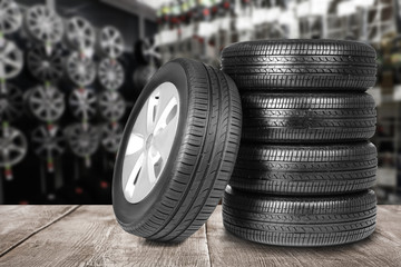 Wall Mural - Car tires on grey wooden surface in auto store