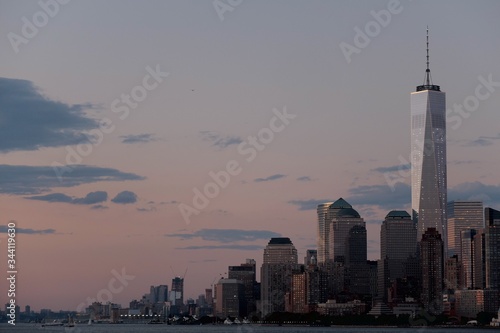 Cuadros en Lienzo One World Trade Center Amidst Buildings In Front Of River Against Sky At Dusk