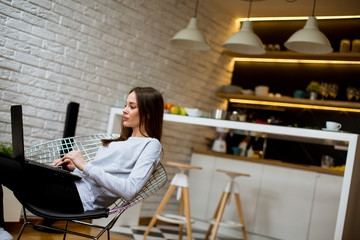 Wall Mural - Beautiful young asian woman with happy smile relaxing while sitting on  chair in living room