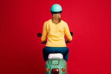 Wall Mural - Rear back behind view of her she nice attractive confident girl sitting on moped driving slowly new purchase buyer owner isolated on bright vivid shine vibrant red color background