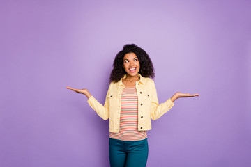 Portrait of dreamy interested minded afro american girl hold hand weighing object think thoughts choice decision solution wear casual style yellow jacket isolated violet color background