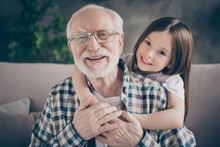 Closeup Photo Of Funny Two People Old Grandpa Little Granddaughter Sitting Sofa Stay Home Quarantine Safety Hugging Piggyback Modern Design Interior Living Room Indoors