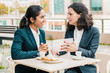 © Mangostar - Businesswomen drinking coffee and using tablet pc. Professional female coworkers in formal wear sitting at table and drinking coffee together in outdoor cafe. Coffee time concept