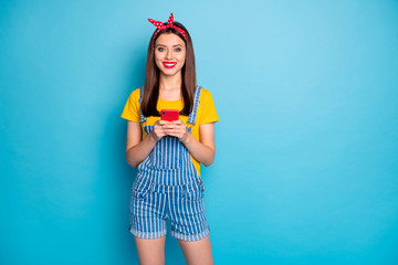 Poster - Portrait of her she nice attractive lovely pretty cheerful cheery girl holding in hands using cell device gadget isolated over bright vivid shine vibrant blue color background