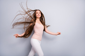 Wall Mural - Profile photo of attractive model lady demonstrate neat long healthy hairstyle flying on air after salon walk street graceful wear beige singlet white pants isolated grey color background