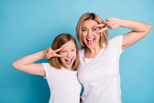 Photo Of Two People Young Beautiful Mom Lady Small Daughter Good Mood Showing V-sing Symbols Near Eyes Saying Hi Friends Wear Casual White S-shirts Isolated Blue Color Background