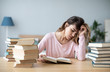 © BestForYou - Upset young woman with books sit at work desk.