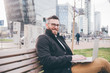 © Eugenio Marongiu - Young handsome caucasian smart man outdoors sitting bench using computer smiling