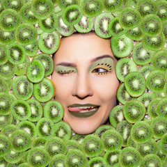 Woman's portrait with green kiwi closeup. Bright kiwi make up.