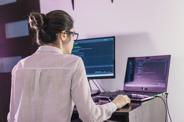 The programmer girl works at the computer.  Information technology by the hands of women. Women in business. The girl works from home.