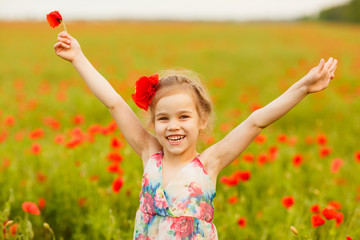 Wall Mural - Beautiful child picking flowers in poppy field