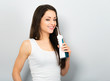© Anastasia.photoyoga - Happy beautiful woman with amazing smile cleaning teeth the dental water wire irrigator on blue baclground with empty copy space. Closeup