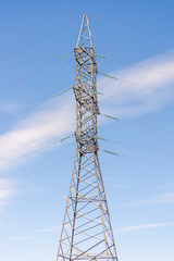 Electricity transmission power lines on the sky background. High voltage towerare on the blue. Electric power line in sunny cloudy day. Post technological lines with powerful wires with copyspace