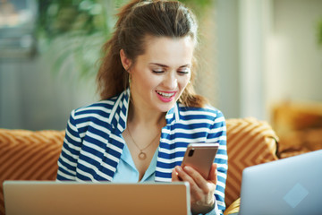 happy trendy woman at modern home in sunny day using devices