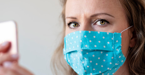 Portrait of woman wearing handmade cotton fabric face mask. Protection against saliva, cough, dust, pollution, virus, bacteria, COVID-19 disease, infection. Coronavirus patient.