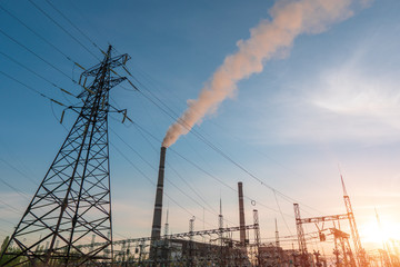 High-voltage power lines at sunset or sunrise. High voltage electric transmission tower