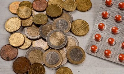 Euro coins are stacked on top of each other in different positions under the tablet.