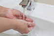 © Oleg - Female soapy hands under running water from the tap. Hygiene and washing, prevention of covid-19 coronavirus