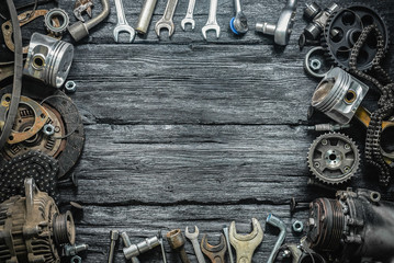 Old car spare parts on a black wooden workbench flat lay background with copy space.