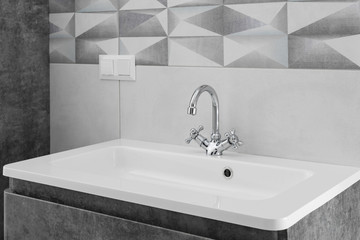 Modern bathroom metal interior with faucet and ceramic white sink.