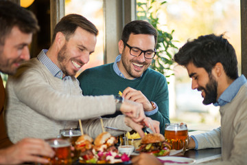 Wall Mural - Friends in pub drinking and eating