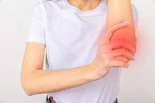 Young Girl Holding Her Elbow Joint Over White Background. Pain And Inflammation In The Elbow.