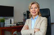 © JENOCHE - Portrait of mature female boss working in office sitting in a chair.