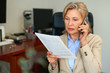 © JENOCHE - Senior businesswoman working with documents at office interior