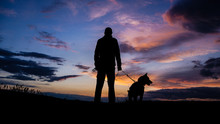 Silhouette Of A Hunter With A Dog At Sunset