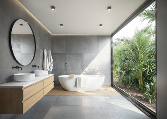 Grey concrete tiled bathroom with opening to a jungle garden a round mirror and a bathtub