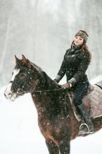 Woman Riding Horse On Snow Covered Field