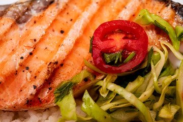 grilled salmon steak with tomatoes and rice, closeup