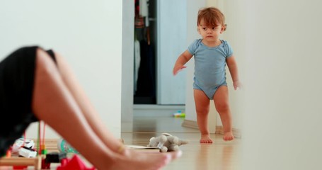 Wall Mural - Baby development walking at home indoors. One year old toddler infant learning to walk