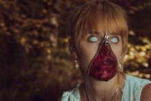 Woman With Zipper And Face Paint Against Tree