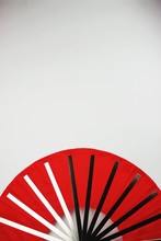 Directly Above View Of Red Foldable Hand Fan On White Background