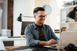 © JustLife - Businessman in office. Handsome man working on lap top.