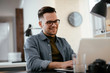 © JustLife - Businessman in office. Handsome man working on lap top.