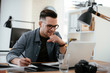 © JustLife - Businessman in office. Handsome man working on lap top.