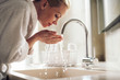 © JustLife - Beautiful woman enjoying in hotel. Young happy women in bathrobe wash her face.