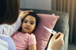 © wutzkoh - Asian female pediatrician is using a thermometer to measure fever for children