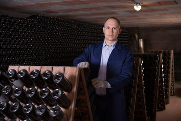 Canvas Print - Wine producer controlling wine aging in winery vault