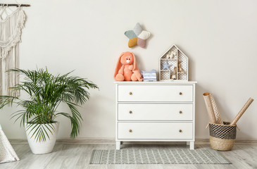 Wall Mural - Chest of drawers with clothes and toys in children's room