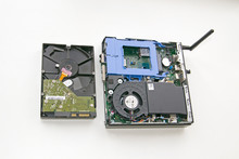 Modern Desktop Computer In Comparison With The Previous Generation Hard Drive, On A Gray Background