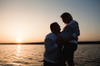 © nagaets - silhouette of a happy family, a pregnant mother and her husbant relaxing by the river