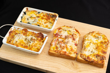 Pizza cheese toasted bread with ham cheese and imitation crab on wooden cutting boards. Isolate on black 