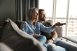 © Drobot Dean - Photo of joyful couple watching TV and using remote control